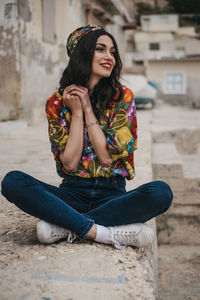 Portrait of a smiling young woman sitting outdoors