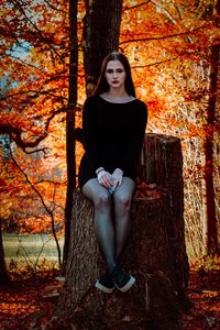 Portrait of young woman in autumn tree