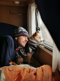 Portrait of man with dog on bed