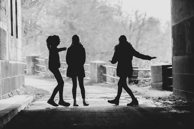 Rear view of silhouette people walking in city