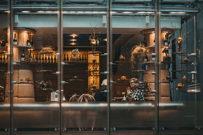 Illuminated restaurant at store seen through glass window