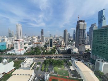 Aerial view of buildings in city against sky