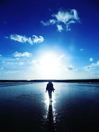 Silhouette man standing in sea against sky