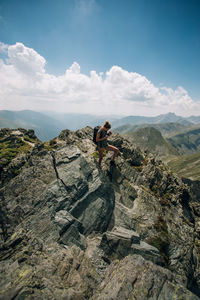 Woman standing on mountain against sky