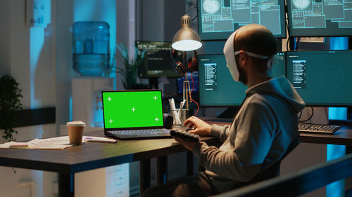 Midsection of man using laptop at office