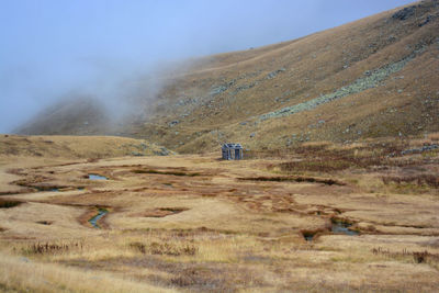 Scenic view of land and mountains against sky