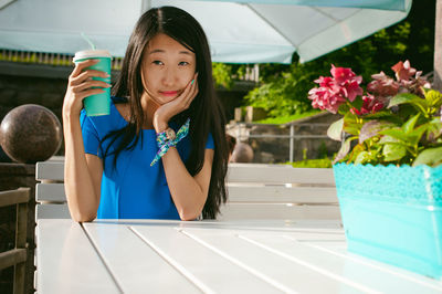 Woman having coffee while sitting at outdoor cafe