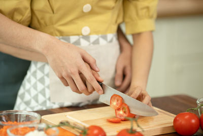 Midsection of man preparing food on cutting board