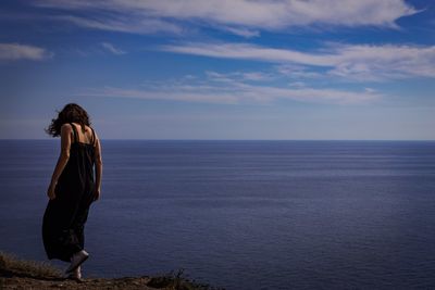 Woman looking at sea against sky