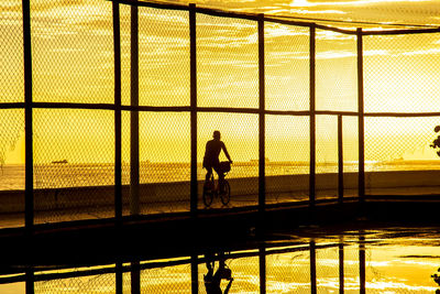 Cyclist exercising on the edge of rio vermelho beach against sunset. city of salvador, bahia.
