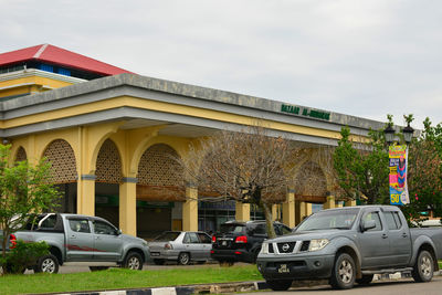 Cars on road by building against sky