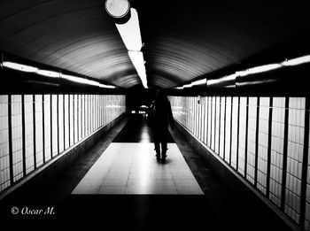 Rear view of woman walking in subway tunnel