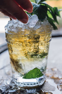 Making a mint julep cocktail with bourbon, fresh mint, crushed ice on whiskey barrel