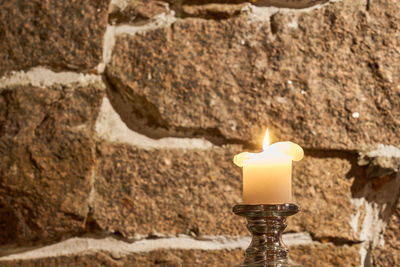 Close-up of lit candles on wall