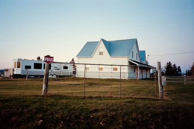 House on field against clear sky