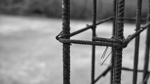 Close-up of rope on fence against lake