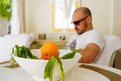 Tourist and orange fruits in a vase in moroccan riad