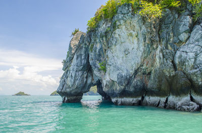 Scenic view of rock formation in sea against sky