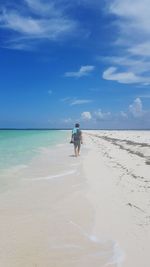 Rear view of people walking on beach