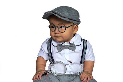 Portrait of cute boy standing against white background