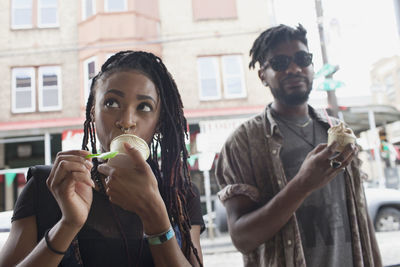 A young man and woman eating frozen yoghurt.