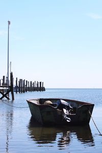 Boat moored on sea against clear sky