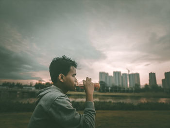 Man photographing with cityscape against sky