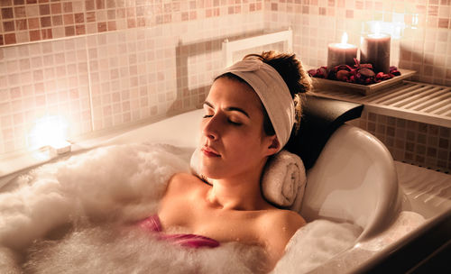 Young woman lying down in bathroom