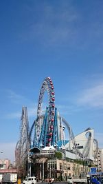 Low angle view of ferris wheel against blue sky