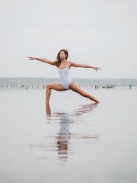 Full length of woman standing against sea