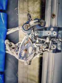 Close-up of rusty metal chain against blue gate