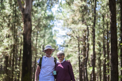 Rear view of man and woman walking in forest