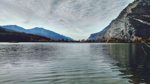 Scenic view of lake by mountains against sky