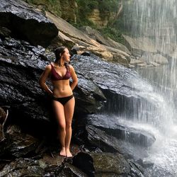 Full length of young woman in bikini standing on rock