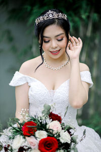 Close-up of woman with pink flower against blurred background