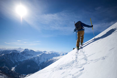 Ski touring uphill with a mountain backdrop