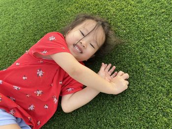 High angle portrait of smiling girl lying on grass