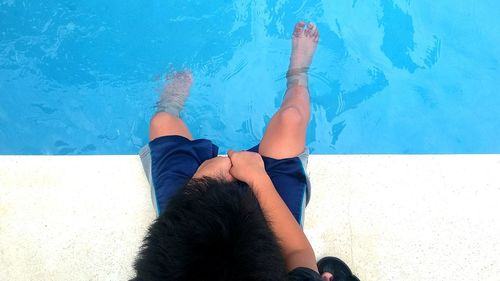 Low section of boy against swimming pool