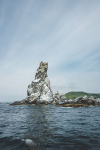 Rock formation on sea against sky