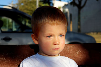   a three-year-old boy with tears in his eyes. sad boy looks into the distance.