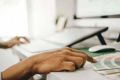 Midsection of man using mobile phone on table