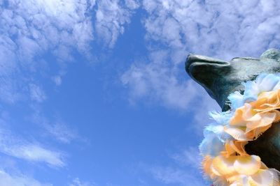 Low angle view of flowering plant against blue sky