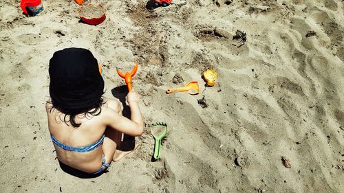 Rear view of girl playing on beach