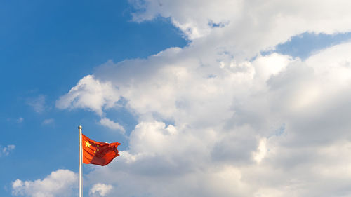 Low angle view of flag flags against sky