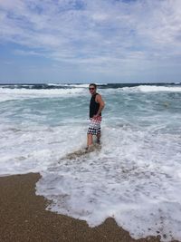 Full length of man standing on beach against sky