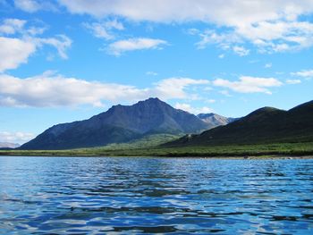 Scenic view of lake by mountains against sky