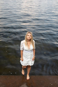 Portrait of a beautiful young woman standing in water