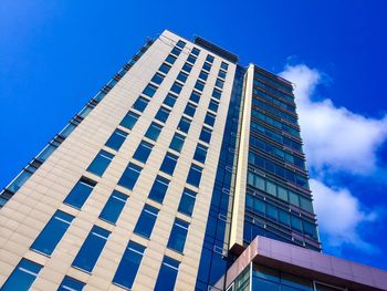 Low angle view of modern building against blue sky