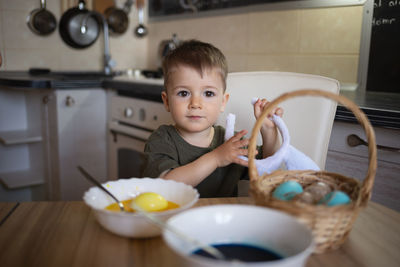 High angle view of cute baby boy with food in bowl on table
