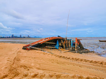 Scenic view of the beach with old shipwreck against the sky
